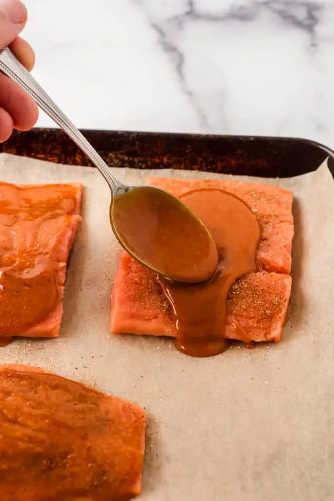 Raw salmon with honey chipotle sauce being spooned over top.