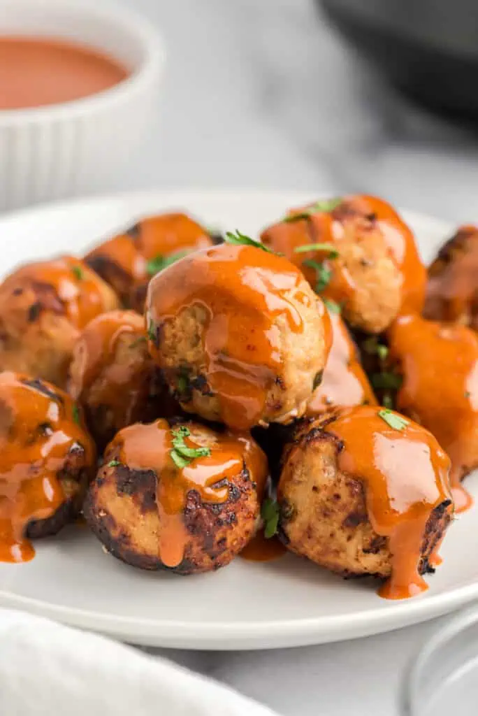 Chipotle honey sauce poured over air fryer turkey meatballs on a plate.