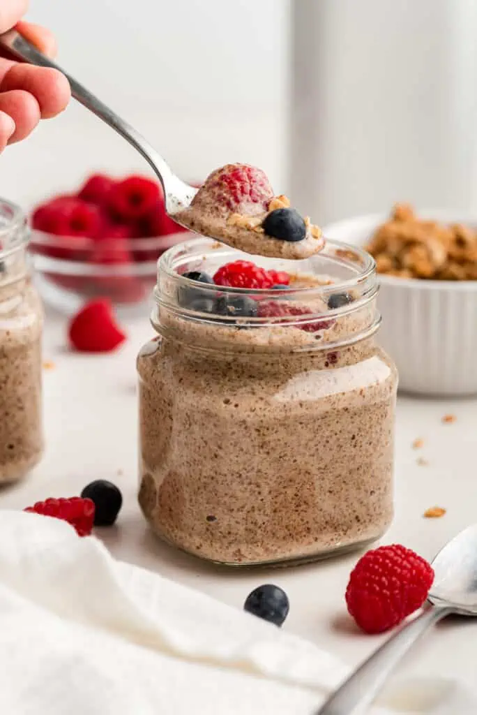 Spoonful of flax pudding and berries over a jar of flax pudding.