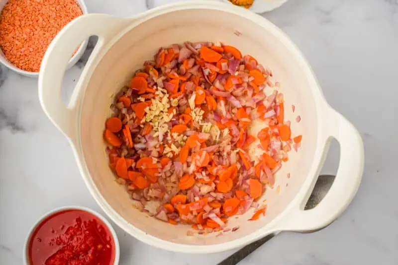 Sauteed veggies in white pot.