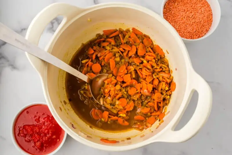Veggies in a pot with vegetable broth after scraping the pot.
