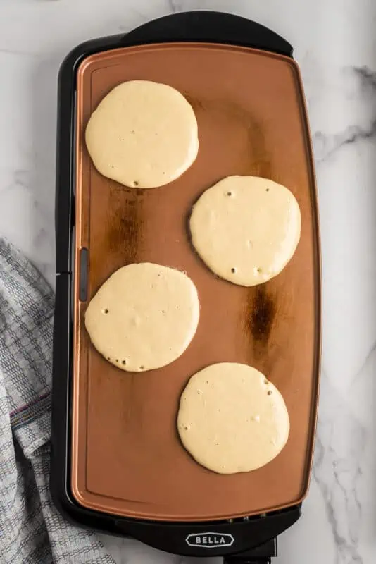 Oat flour pancakes on skillet before cooking.