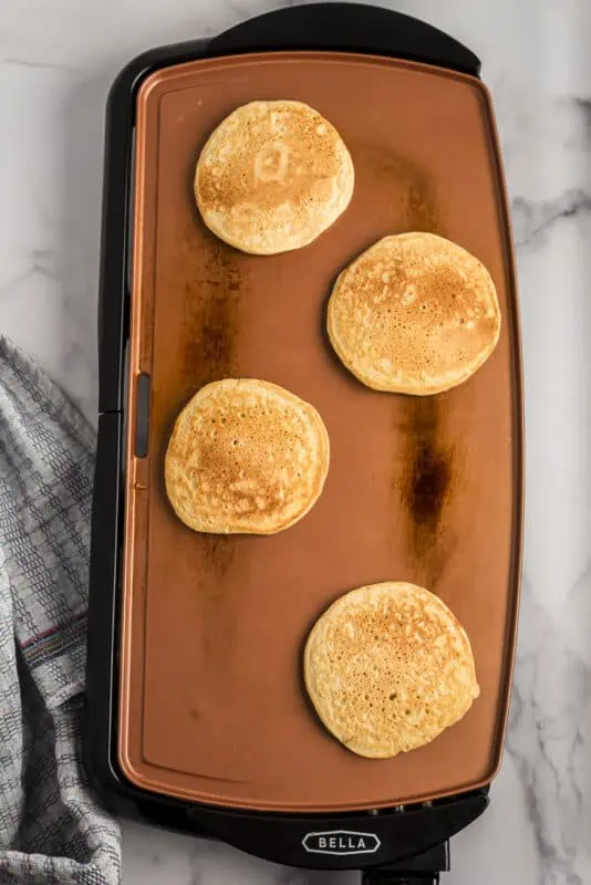 Oat flour pancakes on skillet right after cooking.