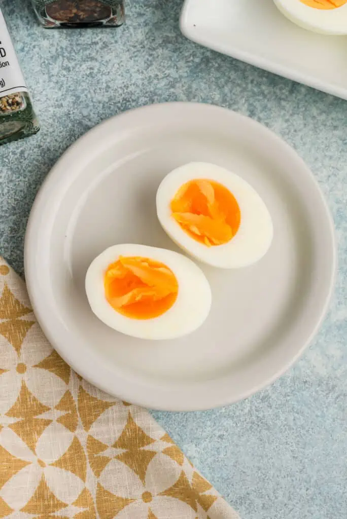 Steamed hard boiled eggs sliced in half on a plate, yolk just set.
