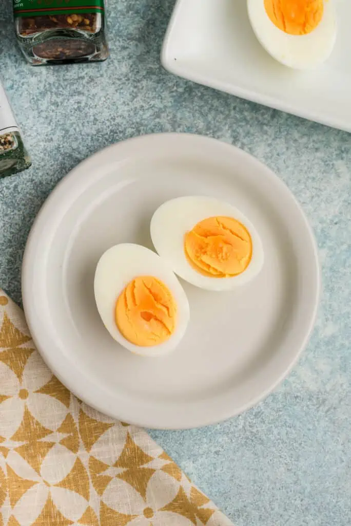 Steamed hard boiled eggs cooked 12 minutes on a plate.