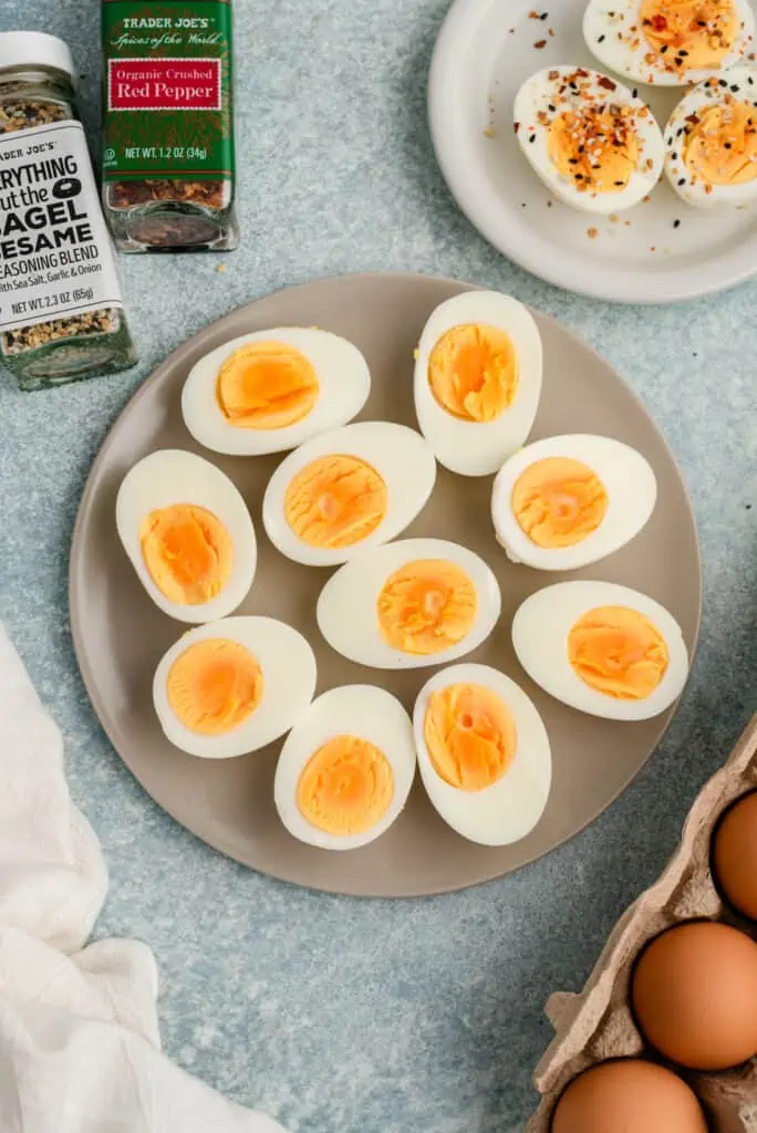 Steamed hard boiled eggs sliced in half on a grey plate.
