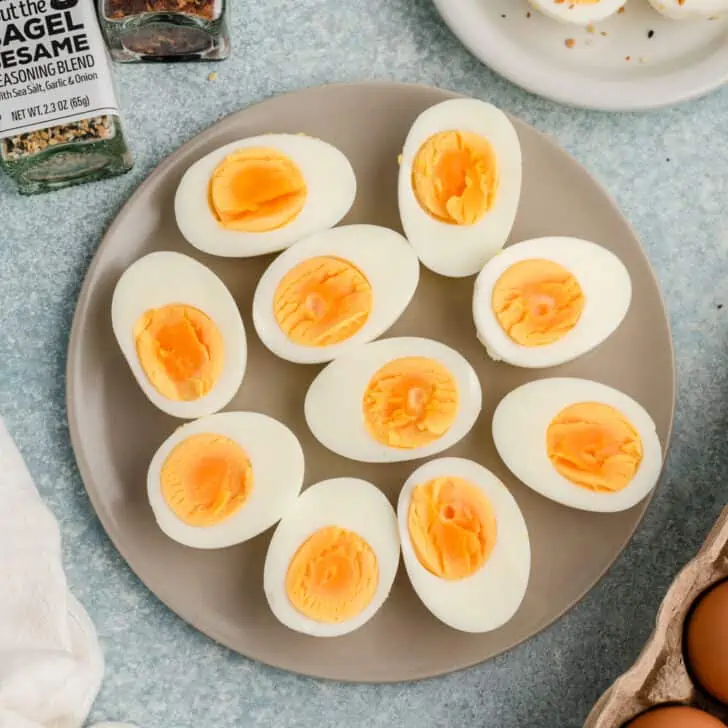 Steamed hard boiled eggs sliced in half on a grey plate.