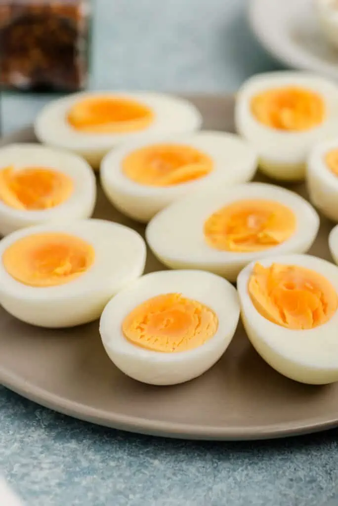 Grey plate filled with sliced steamed hard boiled eggs.