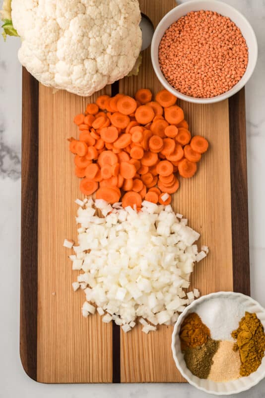Chopped carrots and onion on cutting board.