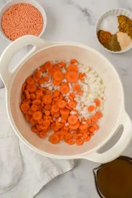Carrots and onion in a pot before cooking.