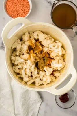 Cauliflower florets with spices on top in pot.