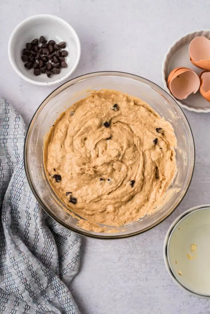 High protein banana bread batter in glass bowl after mixing in chocolate chips.