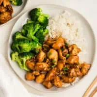 Sticky teriyaki instant pot chicken on a plate with steamed broccoli and rice.