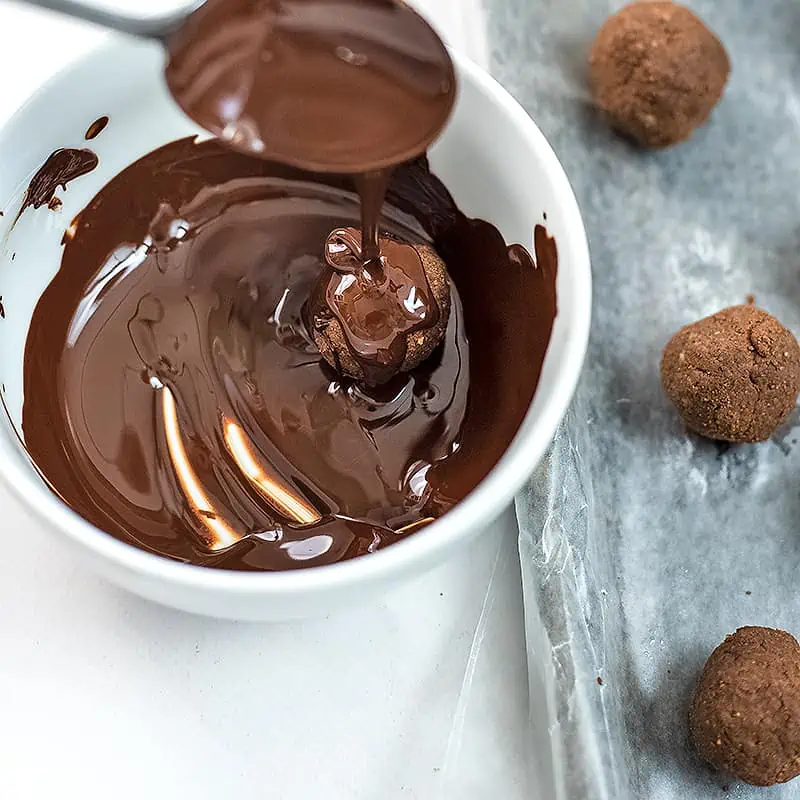 Mint protein ball being dipped in chocolate