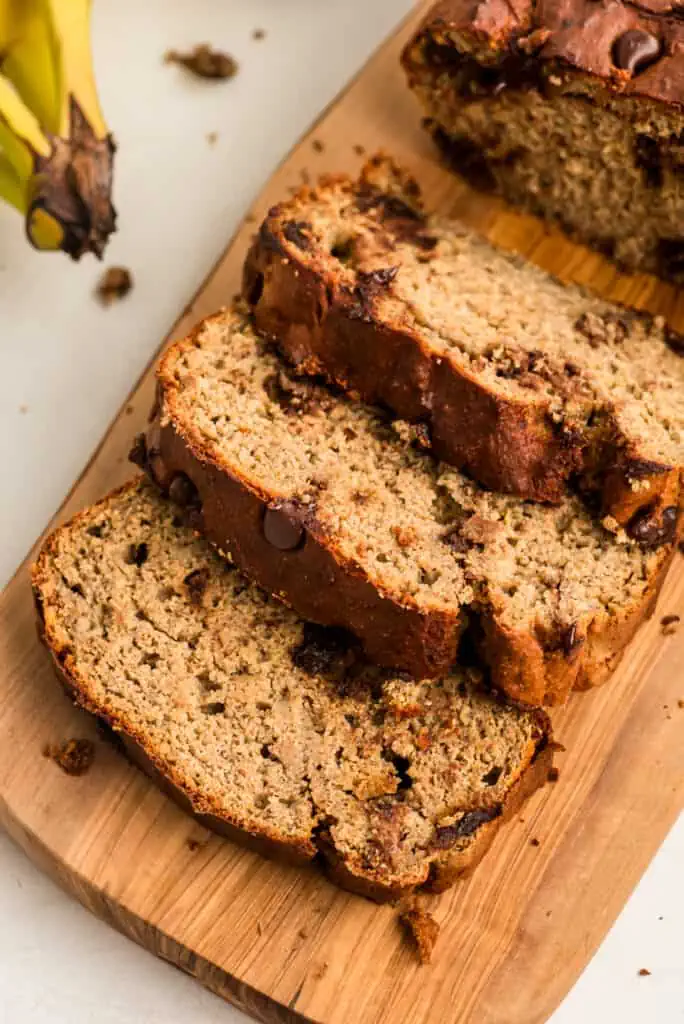 Slices of high protein banana bread on wood board.