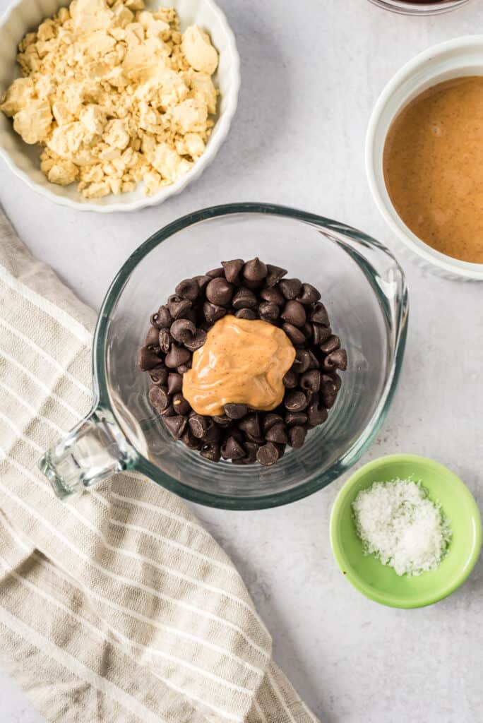 Chocolate chips and peanut butter in glass measuring cup.