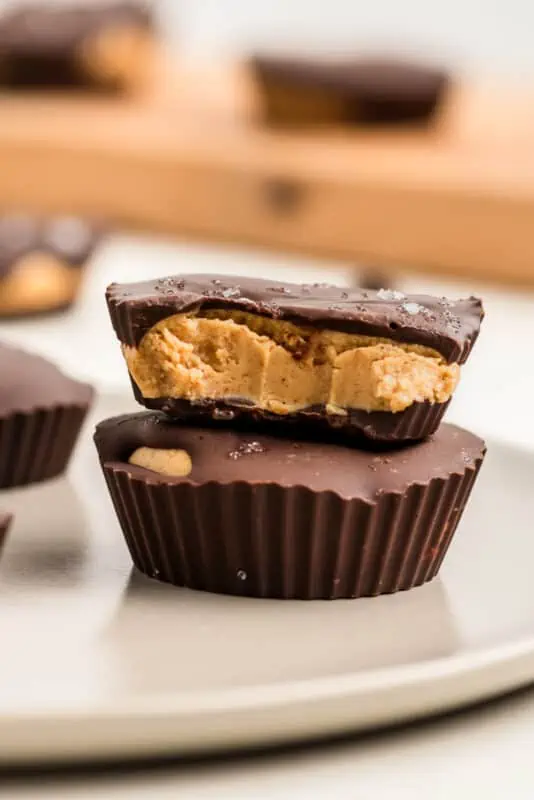 Two peanut butter protein cups stacked on top of each other, with a bite taken.