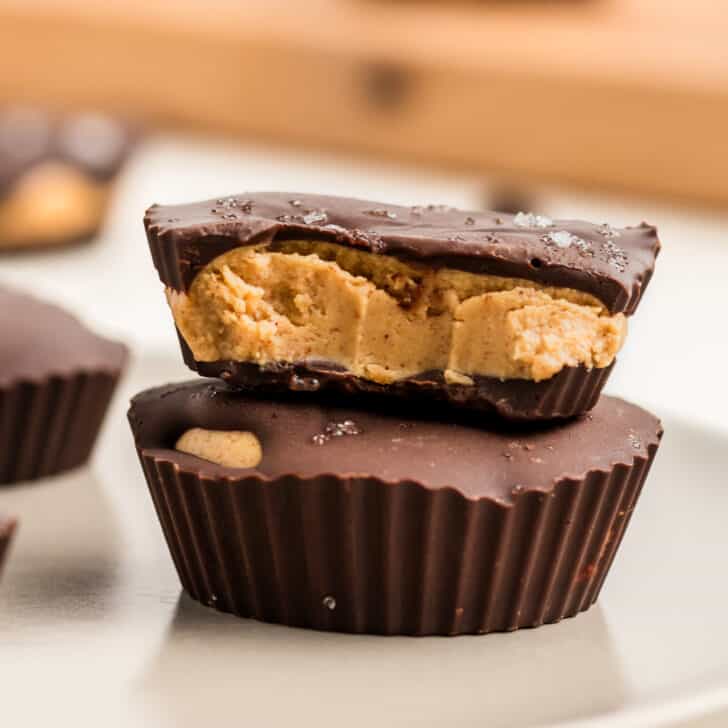 Two peanut butter protein cups stacked on top of each other, with a bite taken.