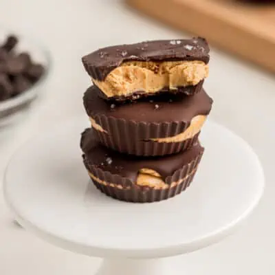 Bite taken out of the top peanut butter protein cup, 3 stacked on each other.