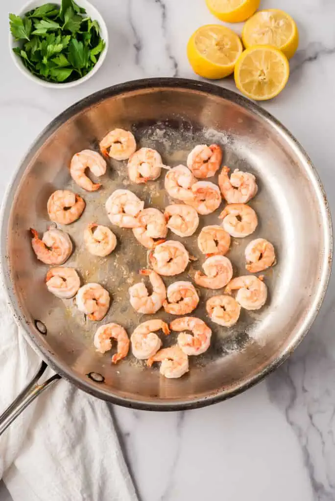 Cooked shrimp in a stainless steel skillet.