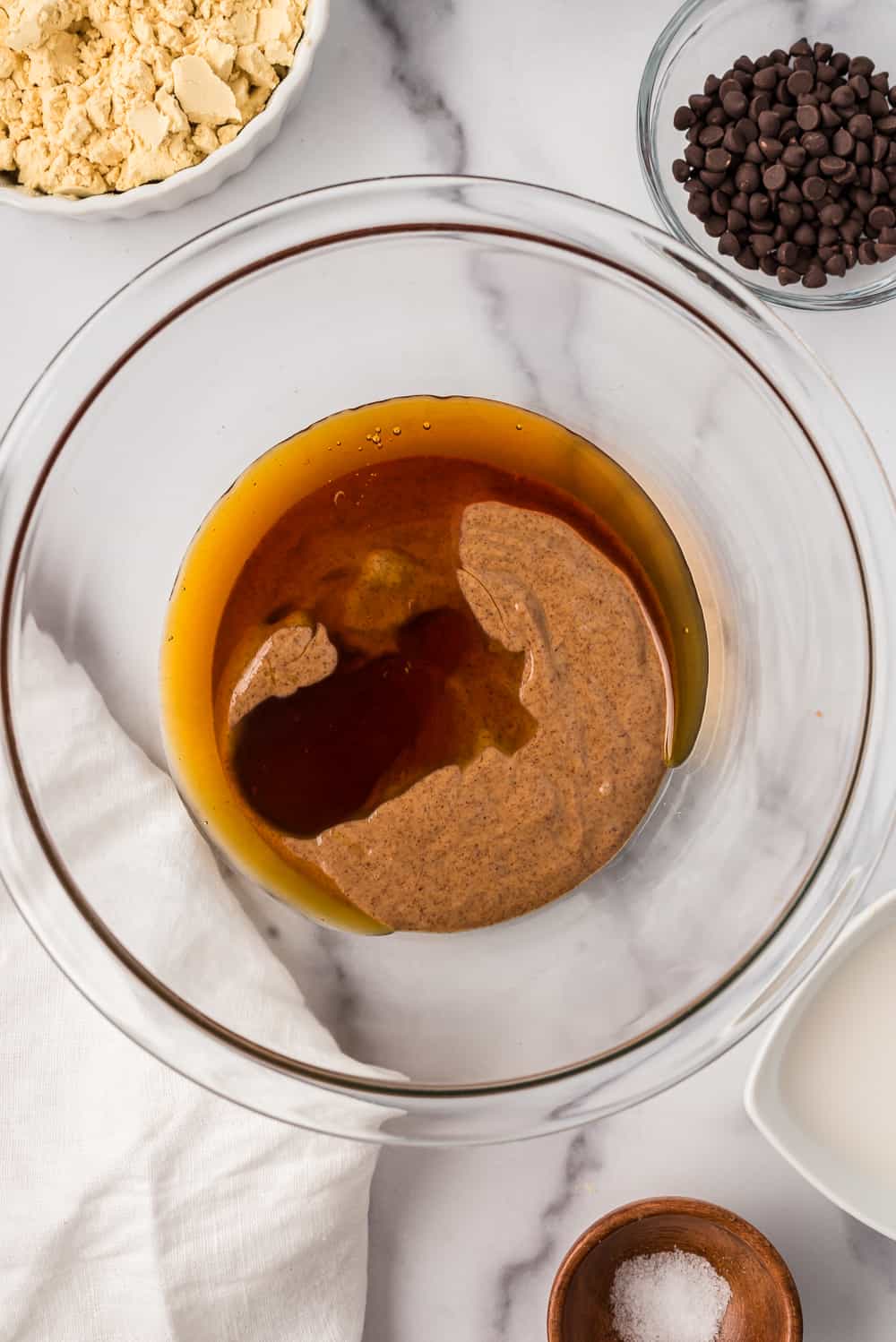 Almond butter and maple syrup in glass bowl.