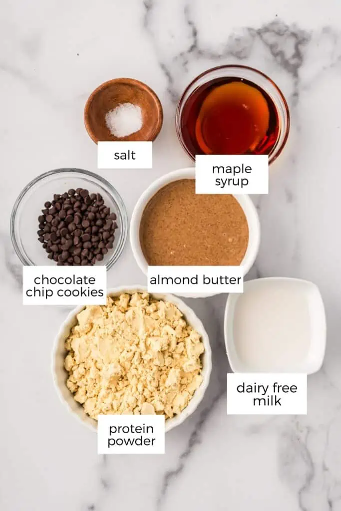 Ingredients to make almond butter protein balls on marble countertop.