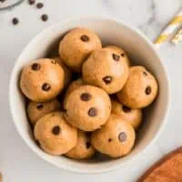 Chocolate chip almond butter protein balls in a white bowl.