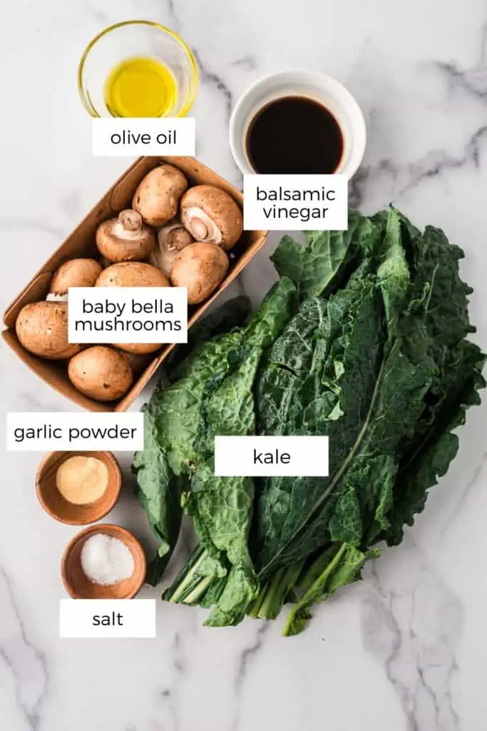ingredients to make kale mushroom saute on marble countertop.