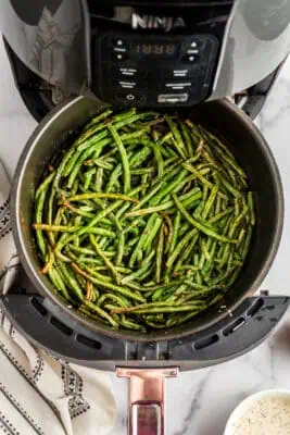 Air fried frozen green beans with white napkin on the side.