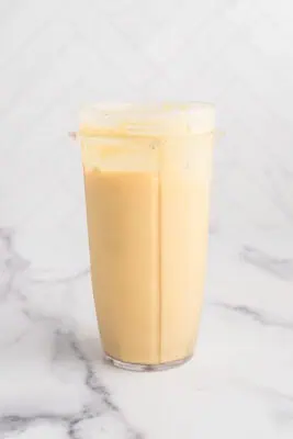 Mango pineapple smoothie in blender after blending.