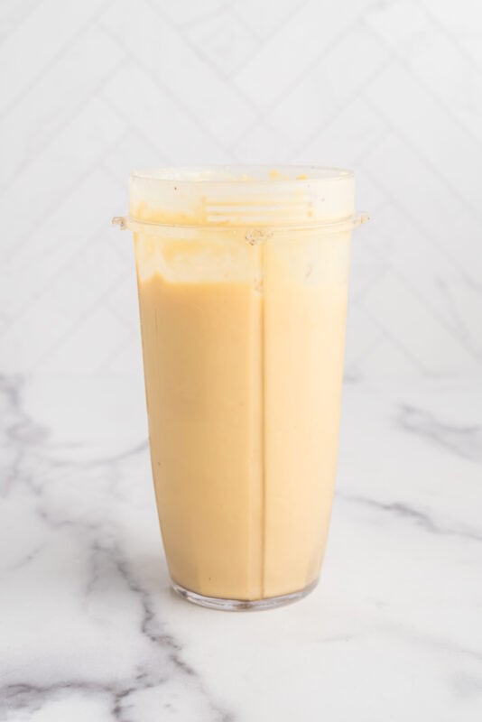 Mango pineapple smoothie in blender after blending.