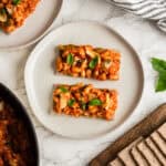 Two pieces of flatbread crackers with pizza beans on top.