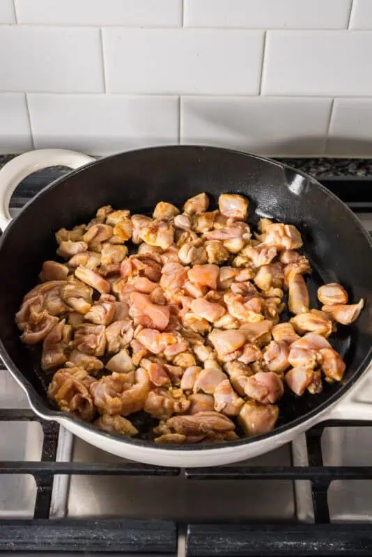 Small chicken bites in a skillet before cooking.