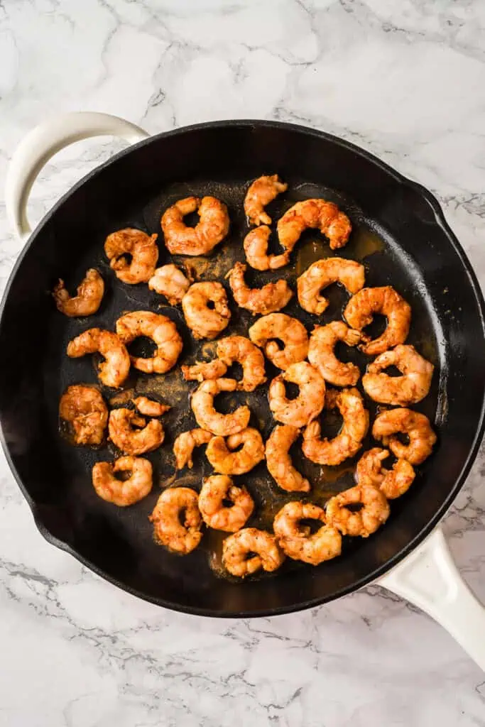 Blackened shrimp in cast iron skillet before cooking.