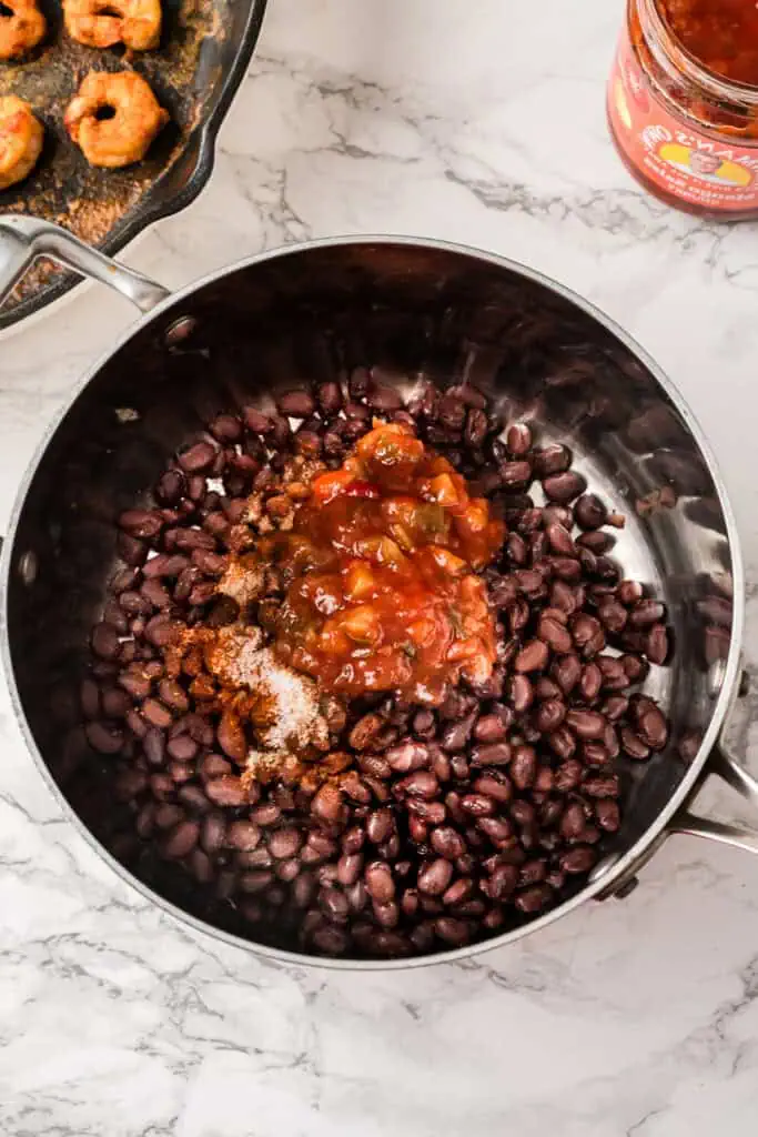 Black beans, mango salsa and spices in a pot before cooking.