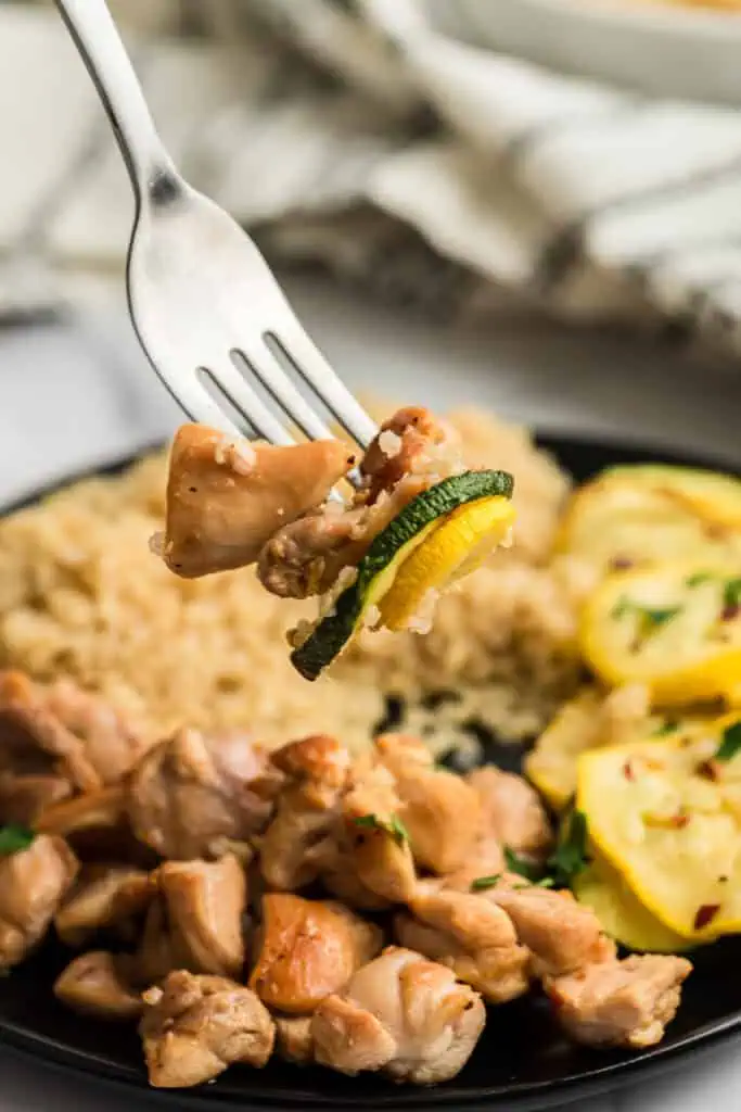 Italian chicken and veggies on a fork.