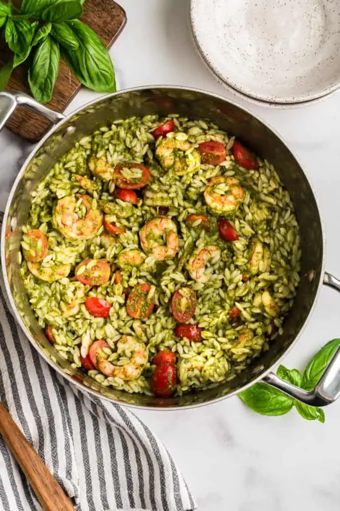 Shrimp orzo pesto pasta in a stainless steel pot.