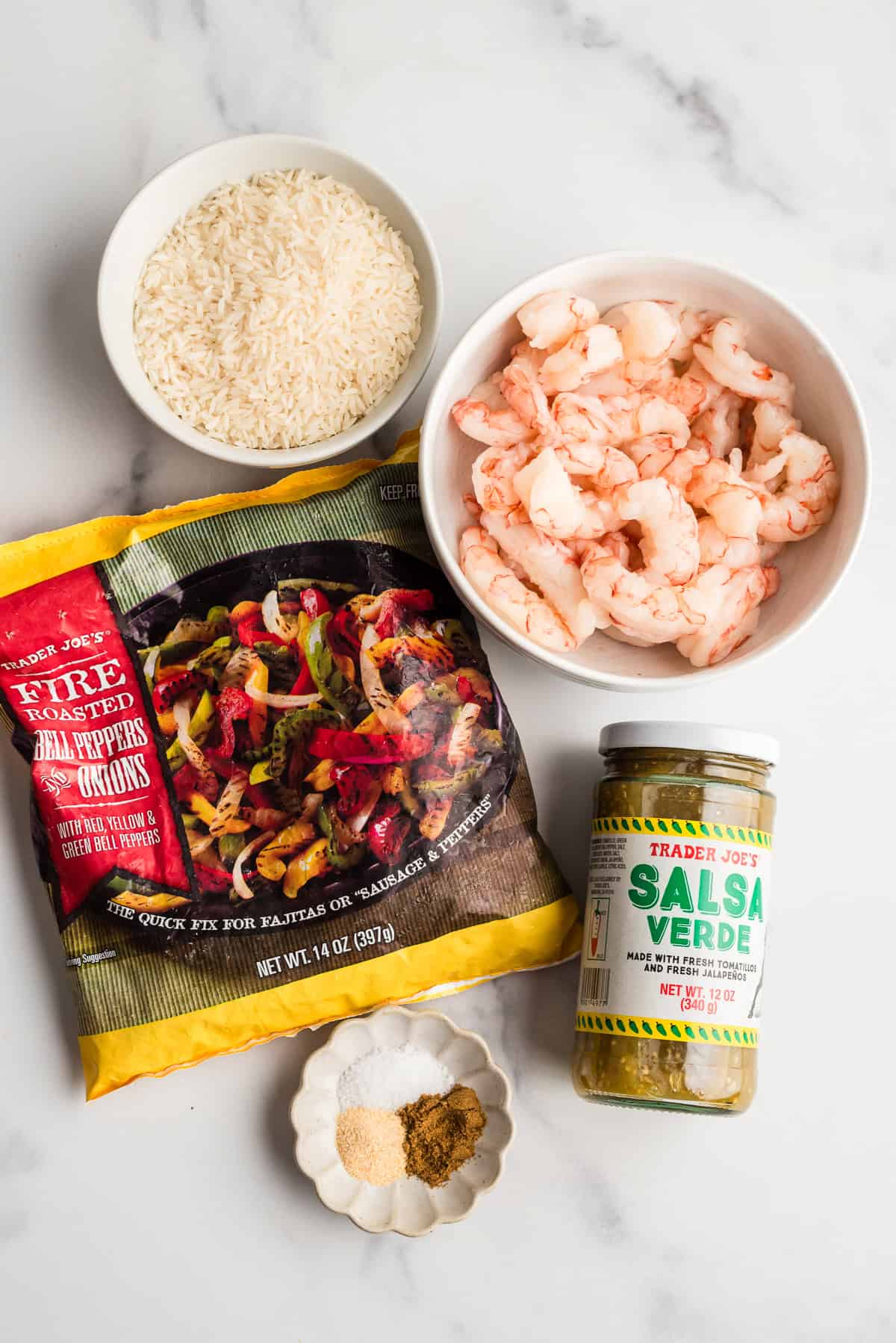 ingredients to make salsa verde shrimp and rice on a marble countertop.
