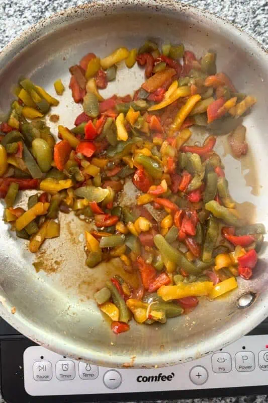Frozen bell peppers added to skillet after cooking chicken.