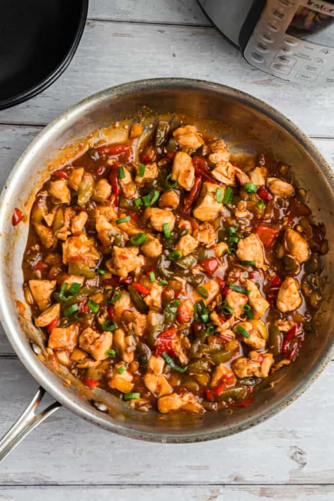 Sweet chili chicken and veggies in a stainless steel skillet.