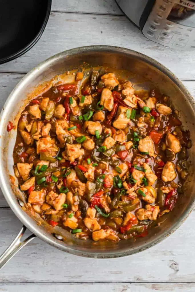 Sweet chili chicken and veggies in a stainless steel skillet.