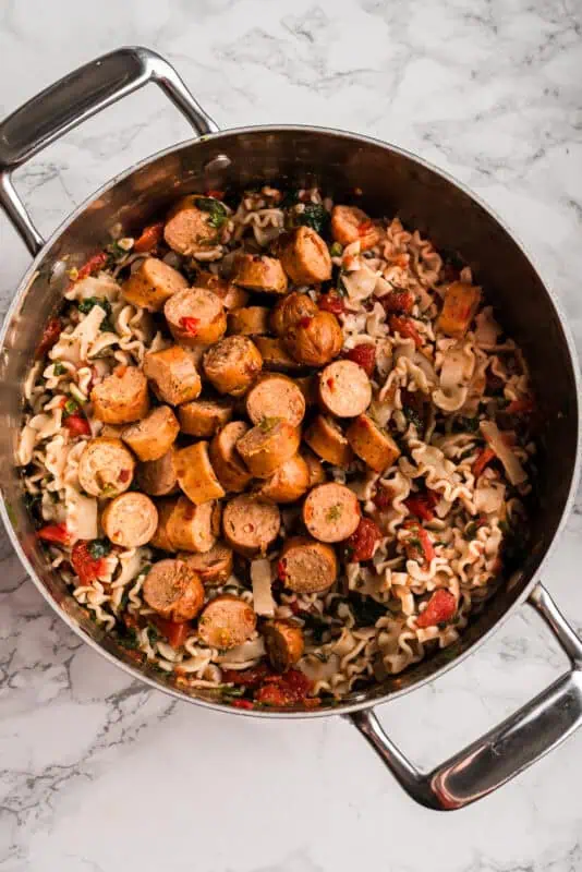Chicken sausage coins added to pot with pasta.