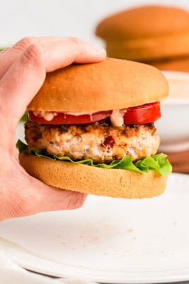 Hand holding chipotle chicken burger.