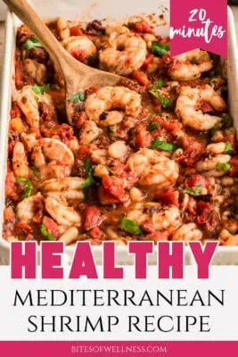 Spoon resting in casserole dish filled with Mediterranean shrimp.