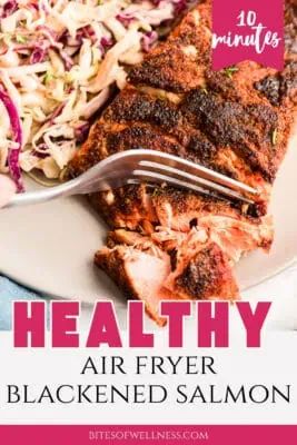 Fork flaking blackened salmon on a plate