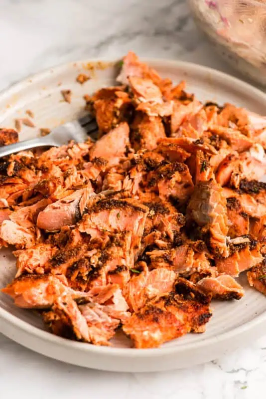 Flaked blackened salmon on a plate.