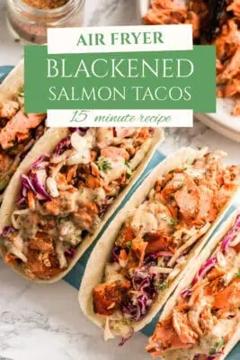 4 blackened salmon tacos stacked next to each other.