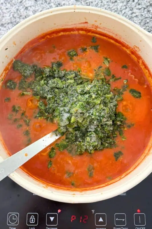 Frozen spinach added to pot with pasta and chicken.