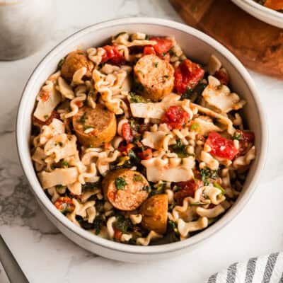 White bowl filled with chicken sausage pasta.