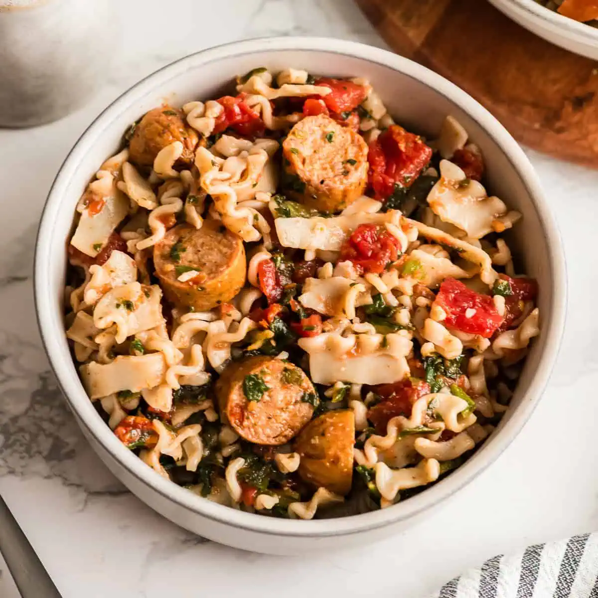 White bowl filled with chicken sausage pasta.